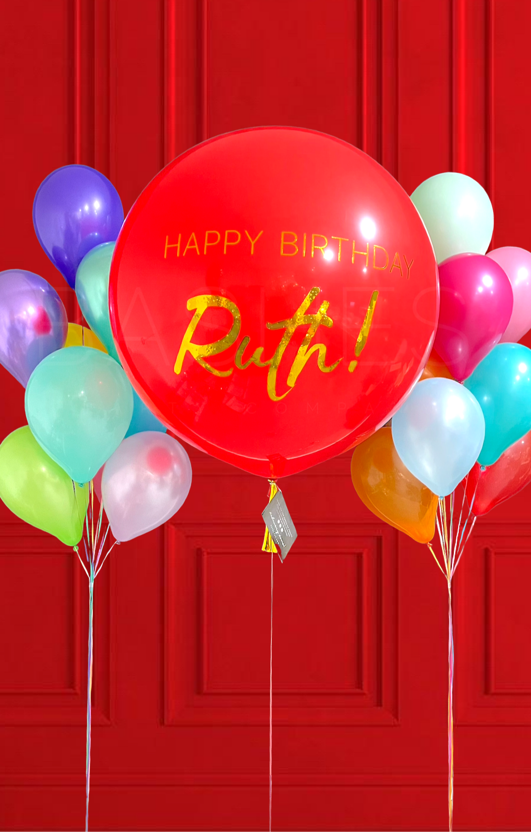 Colorful balloons with a red balloon reading 'Happy Birthday Ruth!' against a red background