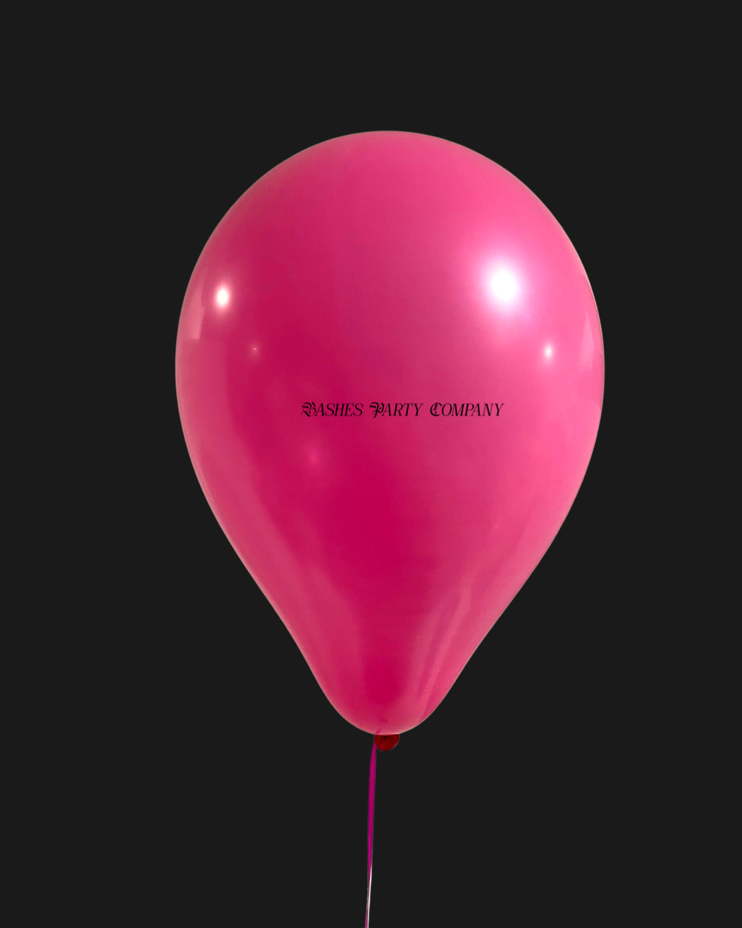 Pink balloon with 'Bashes Party Company' text on a black background