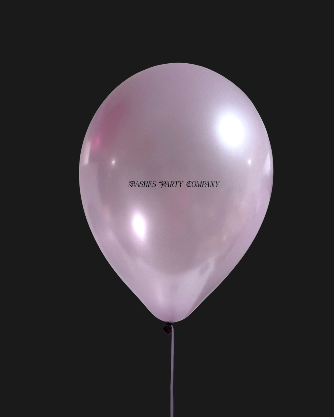 Pink balloon with 'Bashes Party Company' text on a black background