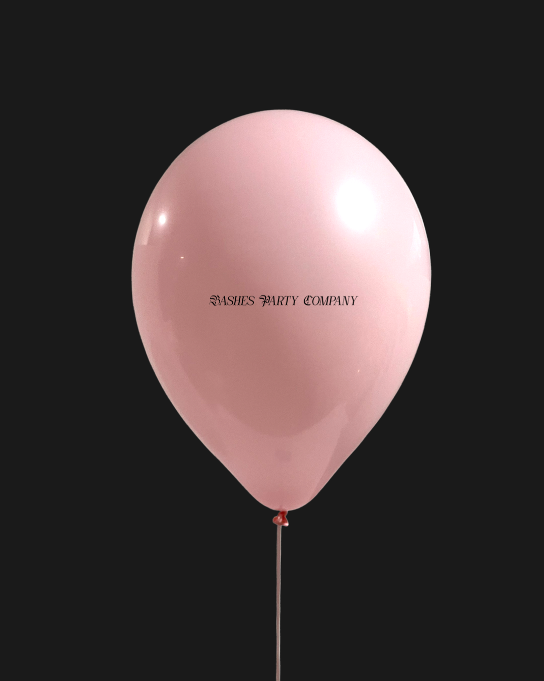 Pink balloon with 'Bashes Party Company' text on a black background