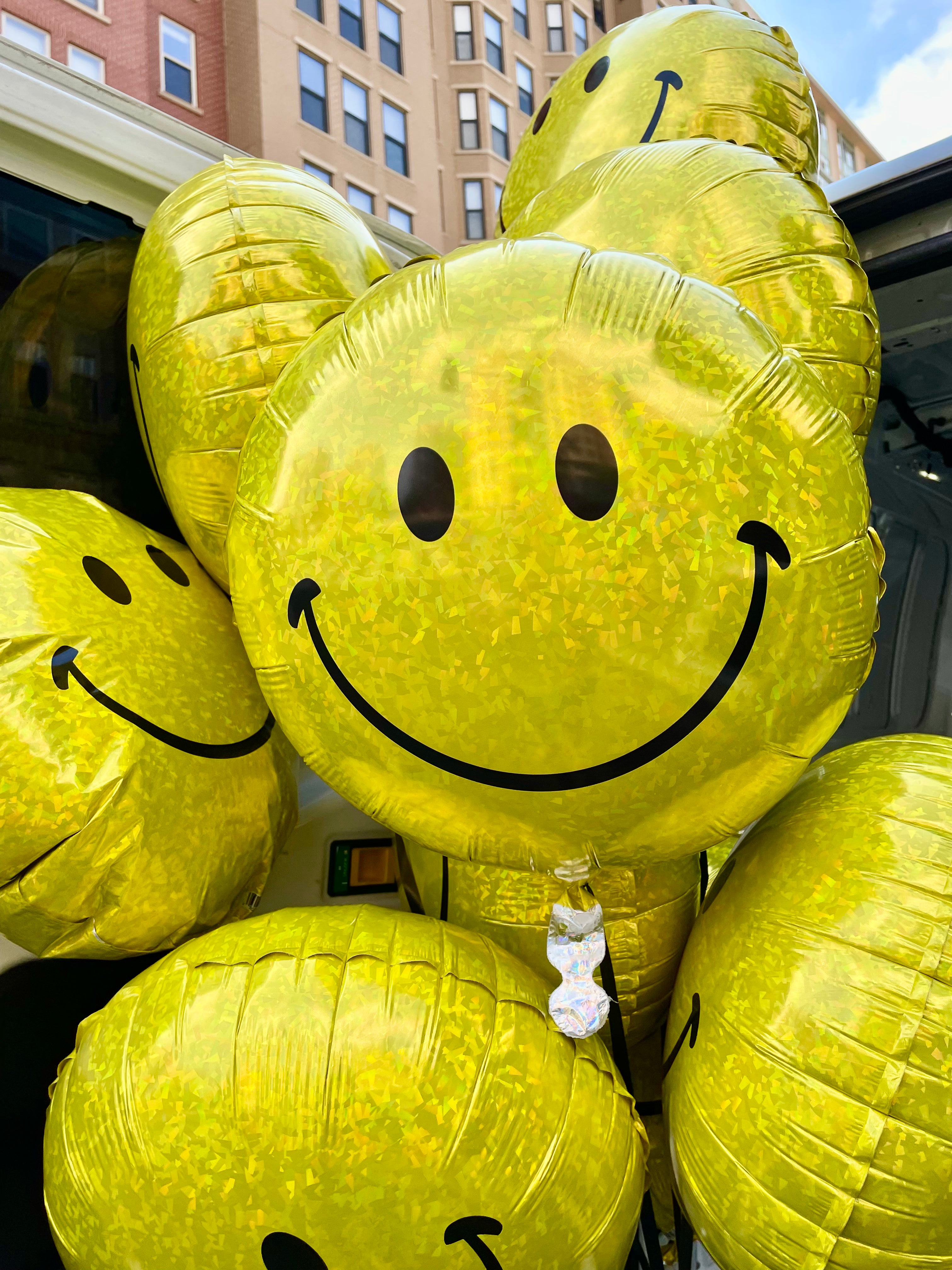 round yellow holographic smiley face balloons